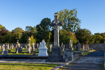 Trees at cemetery against sky