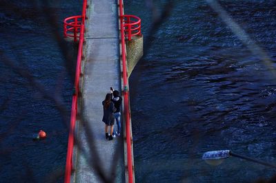 Couple taking selfie on bridge over water