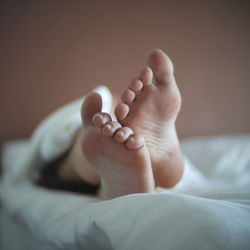 Low section of woman on bed at home