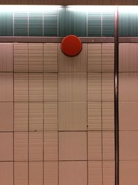 Red ball on tiled floor against wall