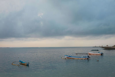 Boats moored in sea against sky