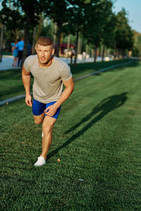 Full length of young man exercising on field