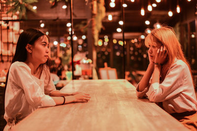 Woman sitting on table at restaurant