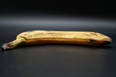 Close-up of bread on table against black background