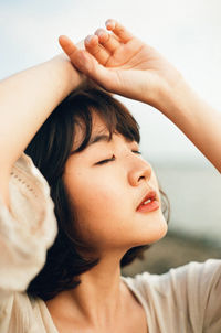 Close-up portrait of a serious young woman with eyes closed