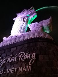 Low angle view of illuminated sculpture against black background