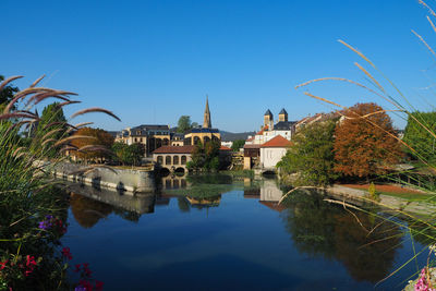 Reflection of buildings and trees against blue sky
