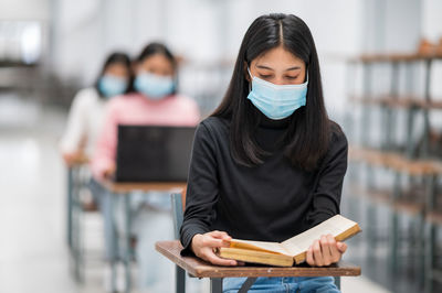 Portrait of a young woman reading book