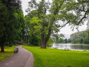 Scenic view of park by lake against sky