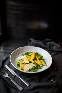 Salad on a plate with mango avocado apple greens and lime