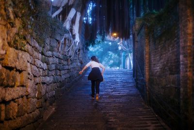 Rear view of woman walking on footpath