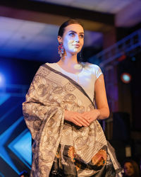 Portrait of young woman standing against temple