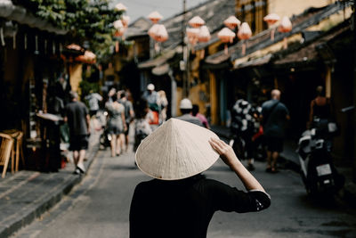 Rear view of woman walking on street in city