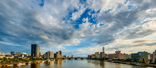 Buildings in city against cloudy sky