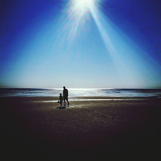 sea, beach, horizon over water, full length, leisure activity, shore, lifestyles, water, sunlight, sand, sun, clear sky, silhouette, men, walking, tranquility, standing, rear view