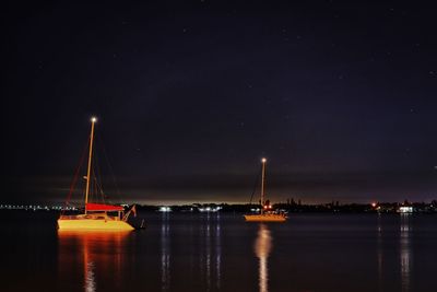 Sailboats in sea at night