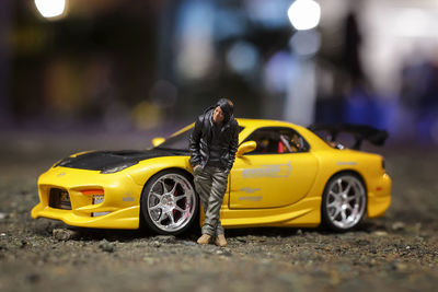 Yellow toy car on street at night