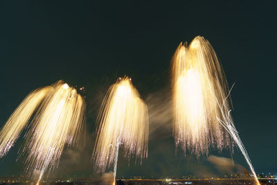 Low angle view of firework display against sky at night