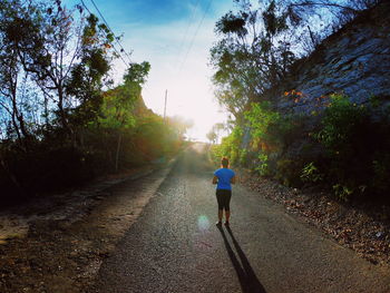 Rear view of man on footpath against sky