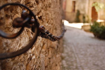 Close-up of chain tied up on metal fence