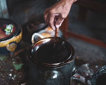 Midsection of person preparing food in container