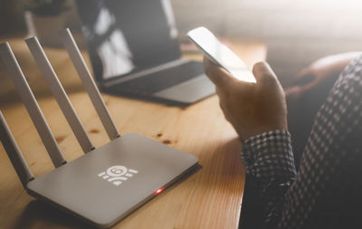 Midsection of person using laptop on table