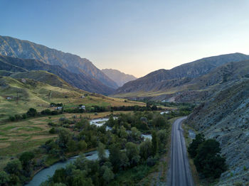 Scenic view of landscape and mountains against clear sky