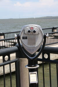 Close-up of coin-operated binoculars on sea