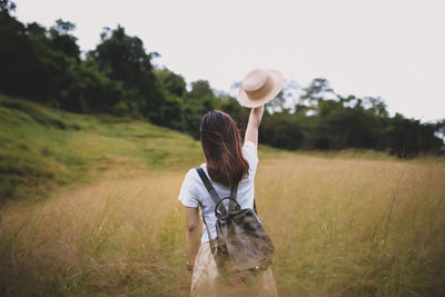 Rear view of woman standing on field