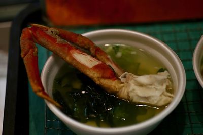 Close-up of meal served in bowl. a japanese snow crab leg in a bow of miso soup.