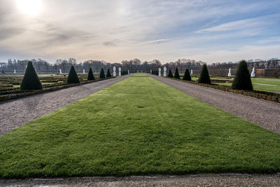 View of green landscape against cloudy sky