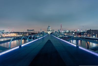 Bridge over river against sky at night