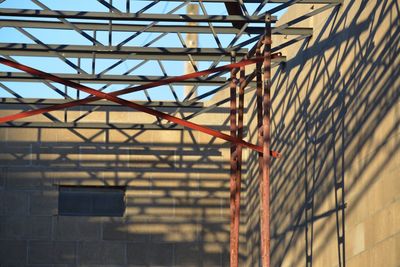 Low angle view of trusses at construction site against sky