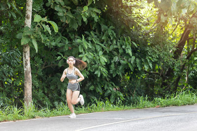 Full length of teenage boy running on road