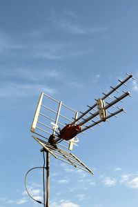 Low angle view of crane against sky