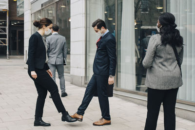 Friends walking on footpath in city