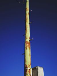 Low angle view of windmill against clear blue sky