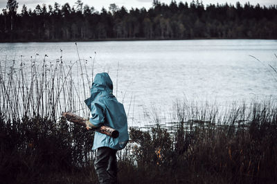 Man standing by lake against plants