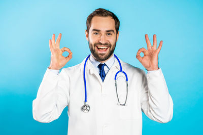 Portrait of smiling man standing against blue sky