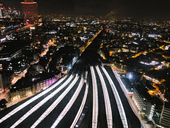 High angle view of illuminated street amidst buildings at night