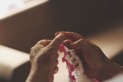 Cropped hands knitting wool at home