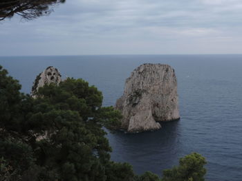 Scenic view of rocks in sea against sky