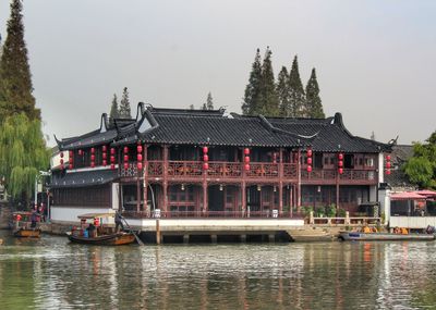 Building by lake against sky