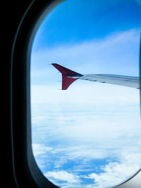 Aerial view of airplane wing against cloudy sky