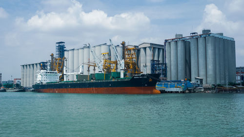 Commercial dock by sea against sky