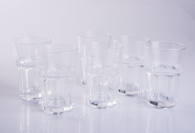Close-up of wine glasses on table against white background