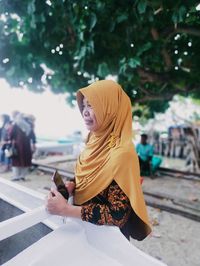 Midsection of woman using mobile phone outdoors