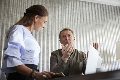 Low angle view of mature professionals with laptop at conference table in board room