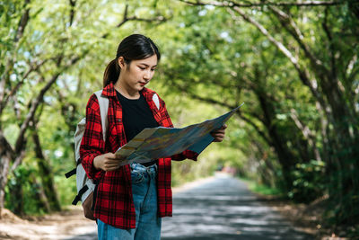 Full length of woman standing against plants