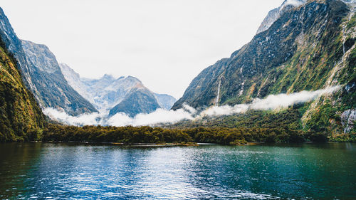 Scenic view of lake by mountains against sky